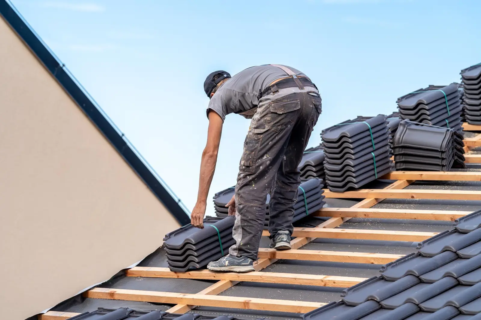 Nouveau toit d'une maison familiale un couvreur construit un toit en carreaux de céramique
